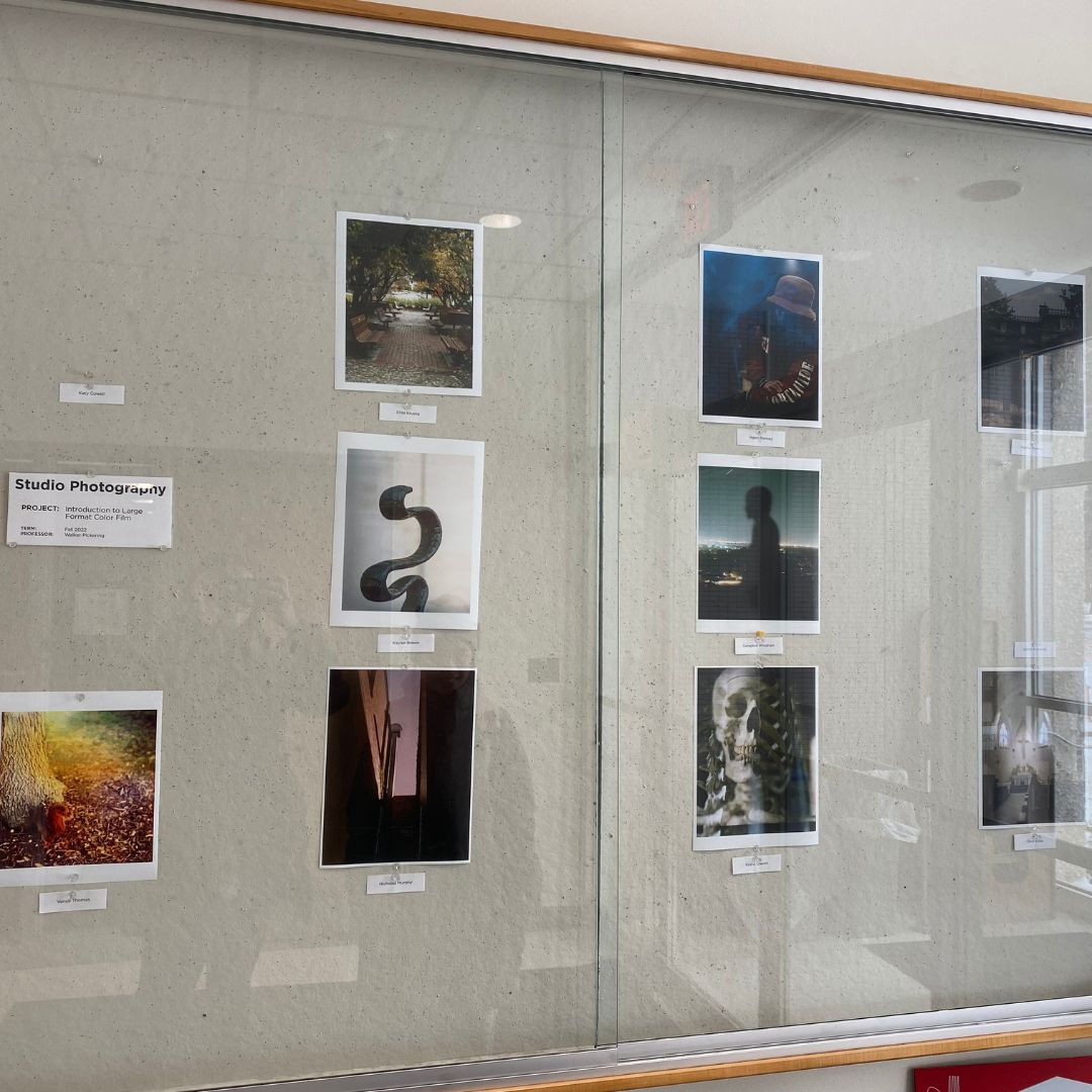 Student-produced photos hang in a display case in Woods Art Building