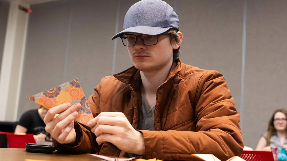 Nathan Nienaber, a junior pre-veterinary medicine major, folds a piece of a paper to make an origami butterfly at the Mind and Craft Club in the Nebraska Union on Monday, Feb. 26, 2024 in Lincoln, Nebraska. [photo by Justin Diep | Daily Nebraskan]