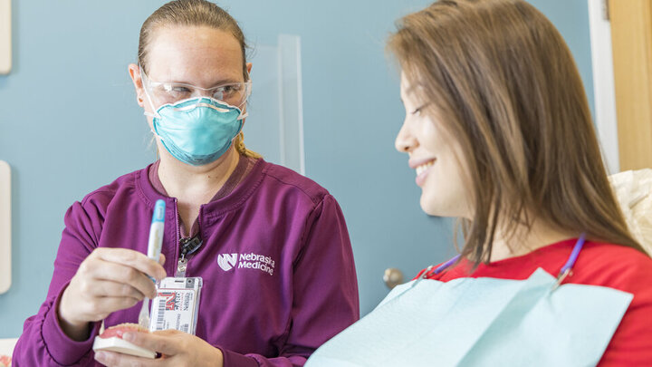 A dental hygienist gives patient education at University Health Center.