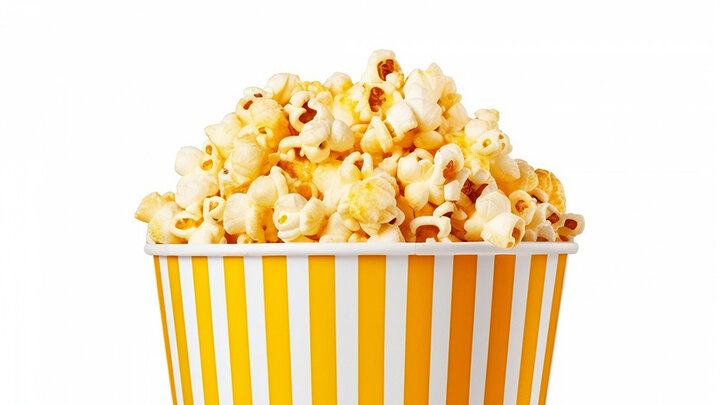 Popcorn in a white and yellow striped bucket.