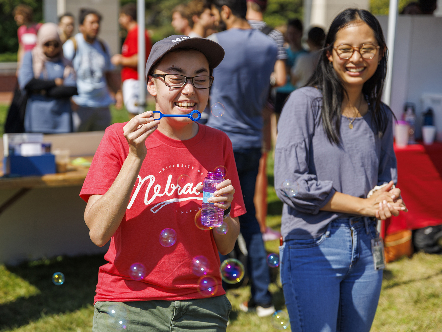 Sarah Roscoe blows bubbles at the UNL Christian Graduate Student table during the Club Fair. August 24, 2022. [Mike Jackson | Student Affairs]