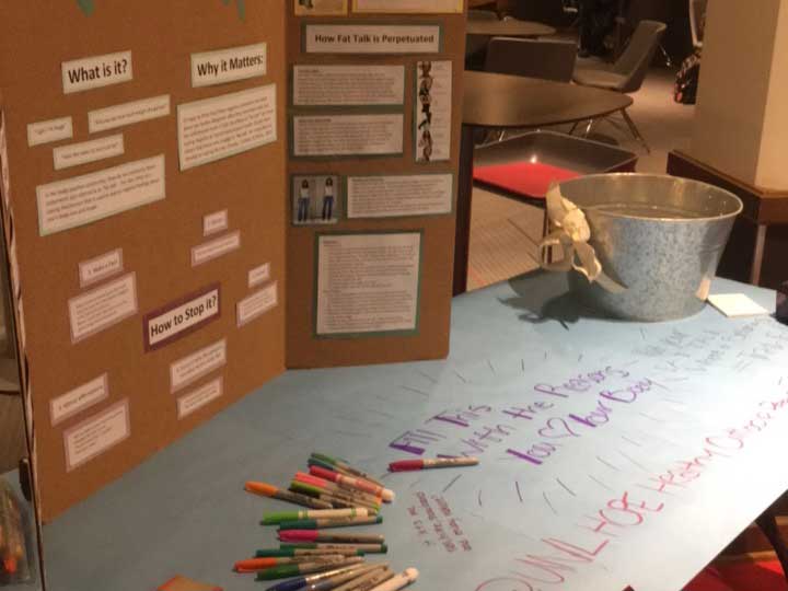 Table with pens and stop the fat talk messages