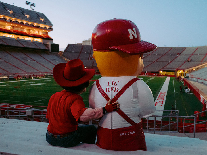 Herbie Husker and Lil' Red sitting in Memorial Stadium