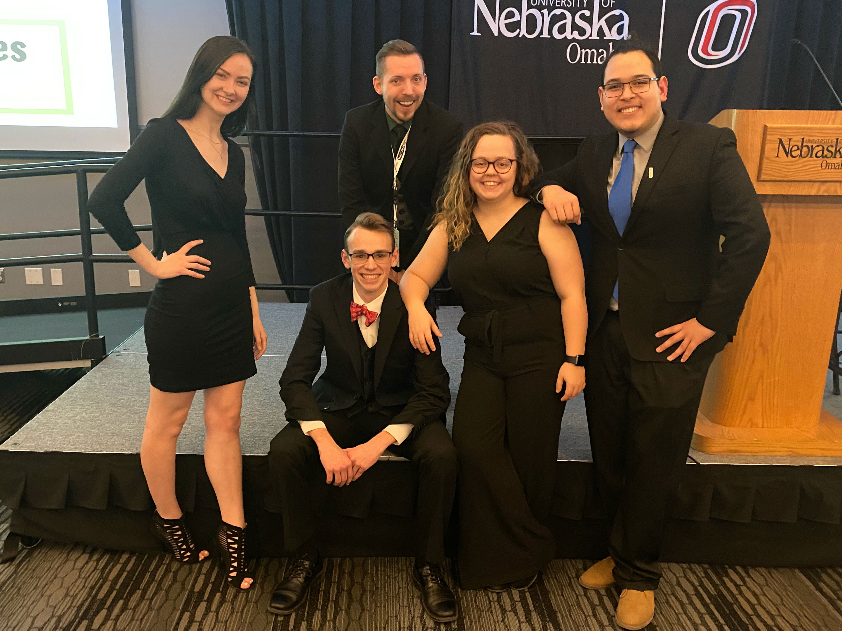 Four Nebraska students pose for a photo with their advisor at the Midwest Affiliate of College and University Residence Halls  conference.