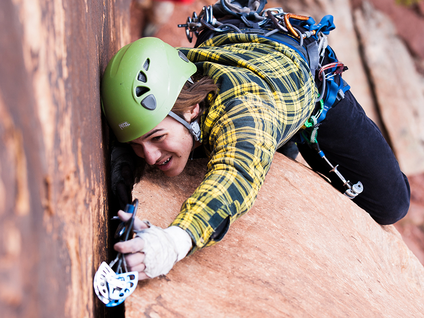 Male student rock climbing in Wichita Mountains. | Photo credit: Doug Lintz.  