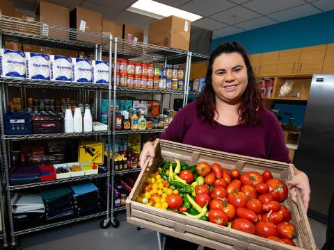 Morgan Smith, a graduate research assistant, shows a tote of fresh vegetables available at Husker Pantry. The pantry and Money Management Center have moved from the Nebraska Union to the University Health Center.