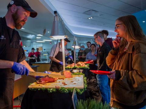 Jake Dietrich (left) serves Grace Clausen at a carving table during the Raikes Beef Co. dinner April 14 at the Cather Dining Center. The event featured hundreds of pounds of beef, all produced some 30 miles east of campus in Ashland.