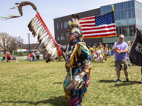 Scott Aldrich, head man dancer (left) leads the colors into the circle at the start of the UNITE powwow on April 23.