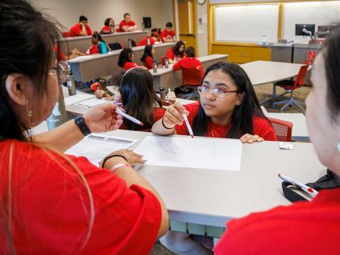 Ana Cortez Martir, a junior from Omaha South Magnet High School, works with her team as they develop a business pitch during their session at the College of Business.