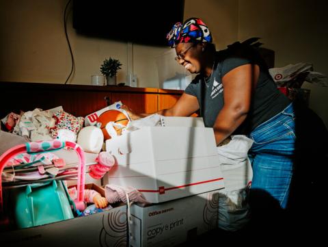 Domonique Cudjo, assistant director, Women’s Center, sorts Holiday for Little Huskers gifts in the center’s conference room.