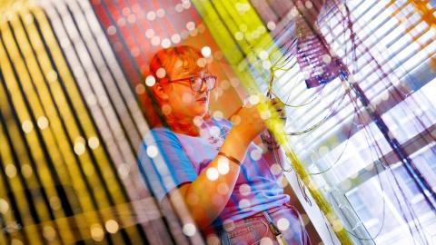 Eden Wilder untangles lights from a multi-colored screen in her campus residence hall room after moving in on Aug. 18. [Craig Chandler | University Communication and Marketing]