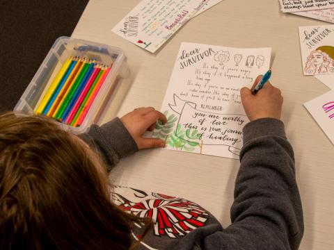 A student writes a note to offer support to survivors of sexual violence.