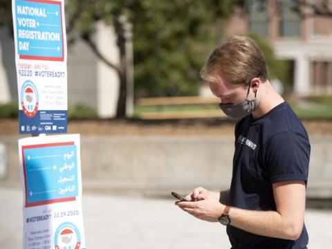 University of Nebraska-Lincoln junior Brent Lucke confirms his voter registration on vote.org after scanning a QR code on the sidewalk outside the Nebraska Union on Tuesday.