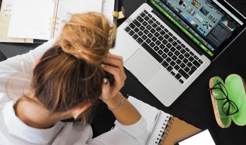 A student stresses over work on the table in front of them