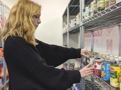 Sophomore Karin Ellefson arranges pantry donations during her volunteer shift at Huskers Helping Huskers Pantry+.