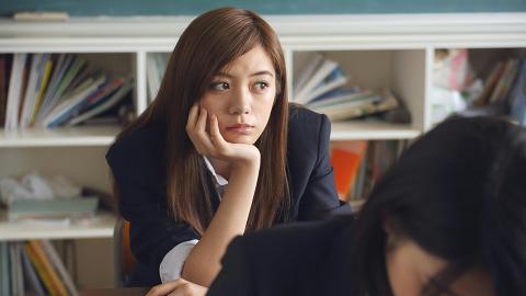 Students looks on with head leaning on their hand